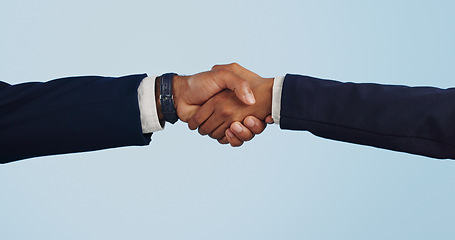 Image showing Business people, handshake and meeting for partnership, deal or agreement against a blue studio background. Closeup of employees shaking hands for b2b, introduction or thank you on mockup space