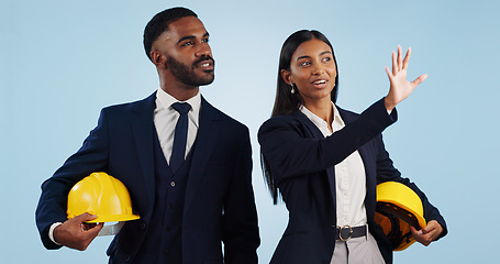 Image showing Business people, architect and planning in vision for building or construction against a blue studio background. Man and woman in engineering or project plan with hard hat for safety on mockup space