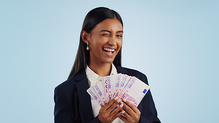 Image showing Business woman, portrait and wink with money fan in financial freedom against a blue studio background. Female person or employee with cash, savings or investment for bonus salary on mockup space