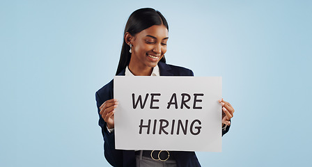 Image showing Happy business woman, hiring and sign for advertising or opportunity deal against a blue studio background. Female person smile with billboard or poster for job recruiting or career on mockup space