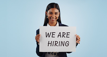 Image showing Business woman, portrait and hiring sign for advertising opportunity or deal against a blue studio background. Female person smile with billboard or poster in job recruiting or career on mockup space