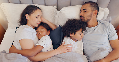 Image showing Tired, sleeping and parents with children in bed on a weekend morning in modern family home. Exhausted, cuddle and young mother and father taking a nap and dreaming with kids in bedroom at house.