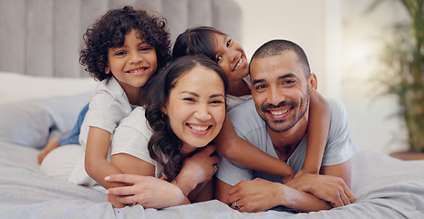 Image showing Portrait, smile and kids with parents in bed relaxing and bonding together at family home. Happy, fun and young mother and father laying and resting with children in bedroom of modern house.