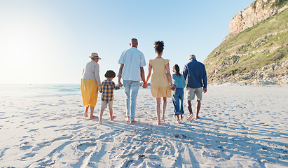 Image showing Holding hands, walking and big family at the beach on holiday, adventure or vacation together. Love, travel and children with parents and grandparents on the sand by the ocean or sea on weekend trip.