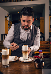 Image showing Barista decorating latte macchiato