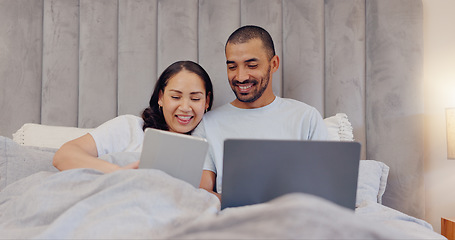 Image showing Tablet, laptop and young couple in bed watching movie and networking on social media at home. Smile, bonding and man and woman relaxing in bedroom with digital technology and computer at modern house