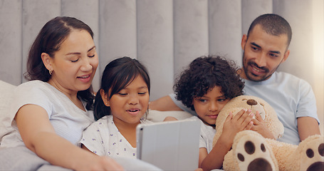 Image showing Tablet, smile and children with parents in bed watching a video on social media together at home. Happy, bonding and young mother and father relaxing with kids in bedroom with digital technology.