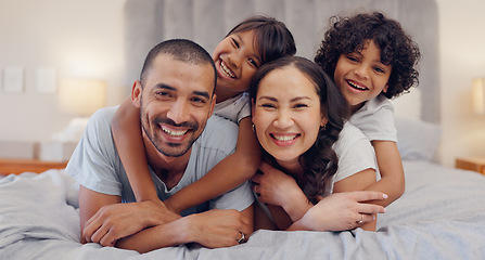 Image showing Portrait, happy and kids with parents in bed relaxing and bonding together at family home. Smile, fun and young mother and father laying and resting with children in bedroom of modern house.