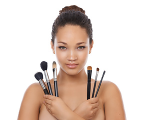 Image showing Woman, portrait and makeup brushes in studio for beauty, foundation and cosmetics for coverage. Face of a young model or artist with skincare, application tools and product on a white background