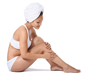 Image showing Young woman, legs and skincare in studio for hair removal results, self care and beauty on floor on a white background. Happy person or model in underwear and body cosmetics, skin care or dermatology