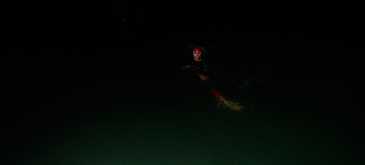 Image showing Authentic triathlete swimmer having a break during hard training on night