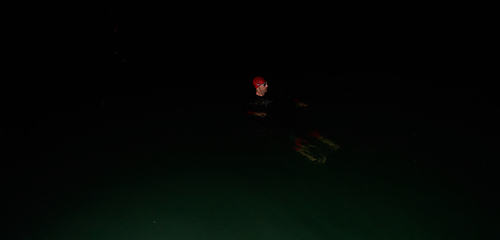 Image showing Authentic triathlete swimmer having a break during hard training on night