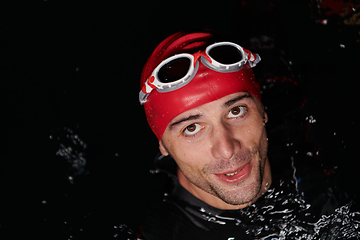 Image showing Authentic triathlete swimmer having a break during hard training on night