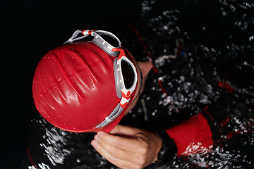 Image showing A determined professional triathlete undergoes rigorous night time training in cold waters, showcasing dedication and resilience in preparation for an upcoming triathlon swim competition