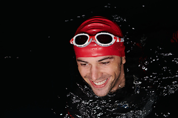 Image showing Authentic triathlete swimmer having a break during hard training on night