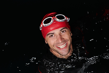 Image showing Authentic triathlete swimmer having a break during hard training on night