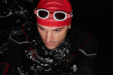 Image showing Authentic triathlete swimmer having a break during hard training on night