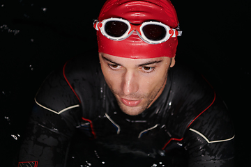 Image showing Authentic triathlete swimmer having a break during hard training on night