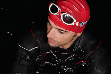 Image showing Authentic triathlete swimmer having a break during hard training on night