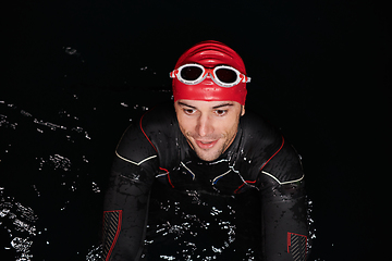 Image showing Authentic triathlete swimmer having a break during hard training on night