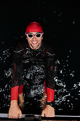 Image showing A determined professional triathlete undergoes rigorous night time training in cold waters, showcasing dedication and resilience in preparation for an upcoming triathlon swim competition