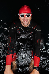 Image showing Authentic triathlete swimmer having a break during hard training on night