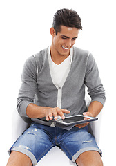 Image showing Man, tablet and smile on chair in studio for social media post, reading ebook and blog on white background. Happy model scroll on digital technology for connection, download app and online shopping
