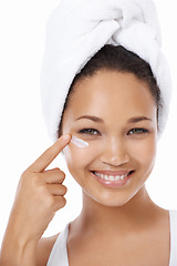 Image showing Happy woman, face and beauty cream, skincare and cosmetics on a white background. Portrait of an African model or person smile and apply moisturizer, lotion or eye product for dermatology in studio