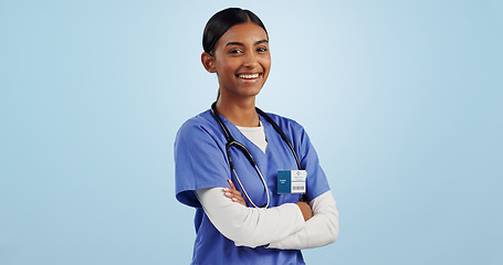 Image showing Happy woman, portrait and professional doctor with arms crossed in medical against a blue studio background. Female person, nurse or confident surgeon smile with stethoscope for healthcare on mockup