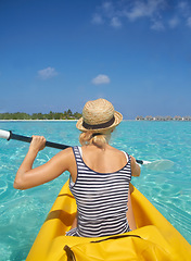 Image showing Woman, kayak and tropical ocean in summer in hat, mockup space or blue sky background by island. Person, boat or back for transport, holiday or travel on vacation in sunshine, water or sea for rowing