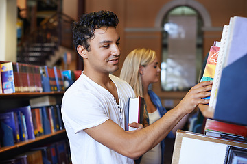 Image showing Student, book and man in a library to search at university, college or school campus for education. Bookshelf, learning or male person with scholarship studying knowledge, research and information