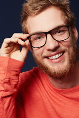 Image showing Man, face and glasses for fashion or eye care with black frame and smile on dark background. Model is happy with prescription lens, designer eyewear and casual clothes in studio with style and vision