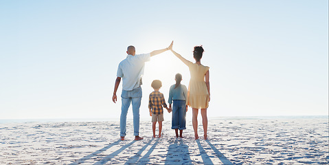 Image showing Back, high five or insurance with a family on the beach together for security, travel or vacation. Flare, safety or cover with a mother, father and children on the sand by the ocean or sea for trust