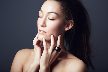 Image showing Woman, touching face and natural beauty with cosmetic care, dermatology and wellness on dark background. Skincare, healthy glow and model pose with eyes closed for skin treatment and shine in studio