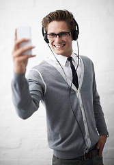 Image showing Business man, headphones and selfie with texting, reading and listening to music by wall background. Influencer, person or employee with photography, audio streaming subscription and social network