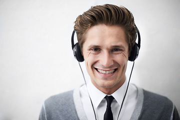 Image showing Business man, portrait and headphones for music, smile and listening to radio by wall background. Employee, person and happy with sound, hearing and audio streaming subscription for podcast with tech