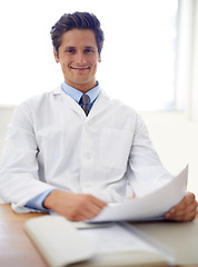 Image showing Smile, document and portrait of man doctor in the office for consultation in a medical hospital. Happy, reading and professional young male healthcare worker with paperwork for research in a clinic.