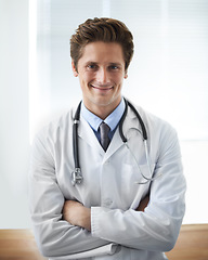 Image showing Smile, crossed arms and portrait of man doctor with stethoscope for positive, good and confident attitude. Happy, pride and young male healthcare worker in medical office of hospital or clinic.