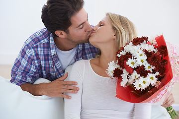 Image showing Man, flowers and kissing in home, happy woman and touch boyfriend for anniversary celebration. Birthday gift, romance and bouquet for love, present and valentines day with romantic gesture and smile