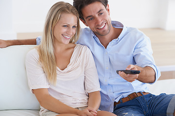 Image showing Happy couple, relax and watching TV for entertainment, holiday or weekend together at home. Man and woman smile with remote for streaming movie, series or show in comfort on living room sofa at house