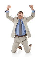 Image showing Business man, hands up in celebration and kneeling on ground for winning at company on white background. Happiness, achievement and fist pump with corporate person on his knees in studio for success