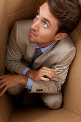 Image showing Businessman, trapped and box at work with frustrated, scared and fear in office for career or startup. Entrepreneur, corporate and person isolated in cardboard at workplace with stress and anxiety