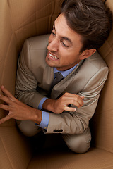 Image showing Businessman, trapped and box at work with stress, scared and fear in office for career or startup. Entrepreneur, corporate and person isolated in cardboard at workplace with frustrated and anxiety