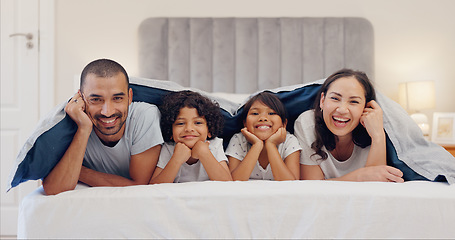 Image showing Portrait, blanket and children with parents in bed relaxing and bonding together at family home. Smile, happy and young mother and father resting and having fun with kids in bedroom of modern house.