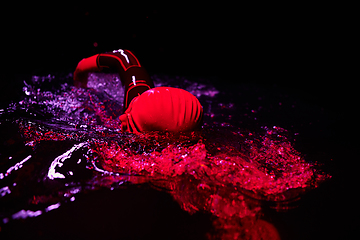 Image showing Authentic triathlete swimmer having a break during hard training on night neon gel light