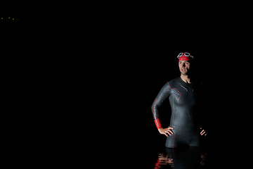 Image showing Authentic triathlete swimmer having a break during hard training on night