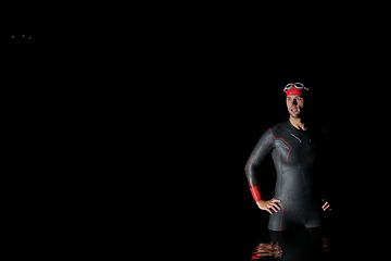 Image showing Authentic triathlete swimmer having a break during hard training on night