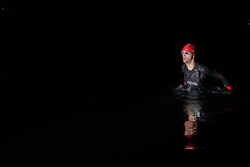 Image showing Authentic triathlete swimmer having a break during hard training on night