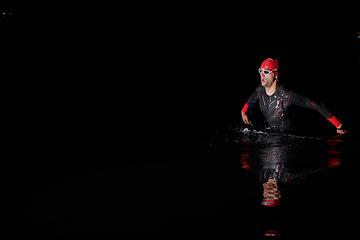 Image showing Authentic triathlete swimmer having a break during hard training on night