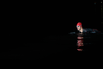 Image showing Authentic triathlete swimmer having a break during hard training on night